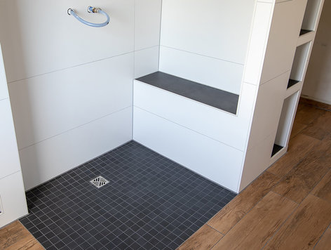 Floor-level shower with bench built with the Qboard construction board system
